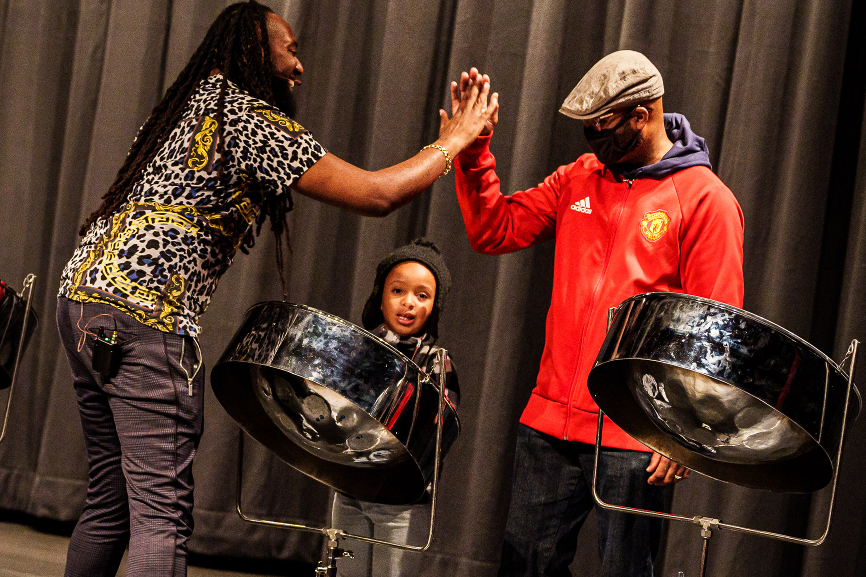 Person and child playing steel drums
